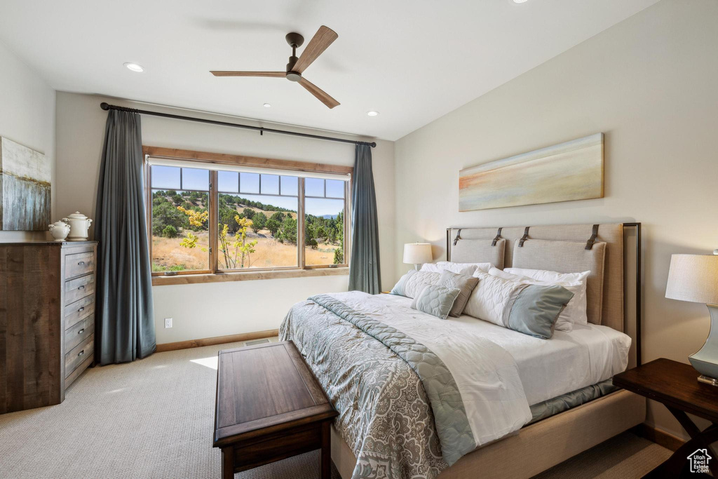 Carpeted bedroom featuring ceiling fan