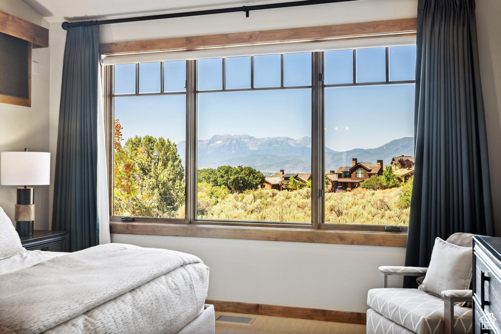 Bedroom featuring a mountain view, multiple windows, and carpet