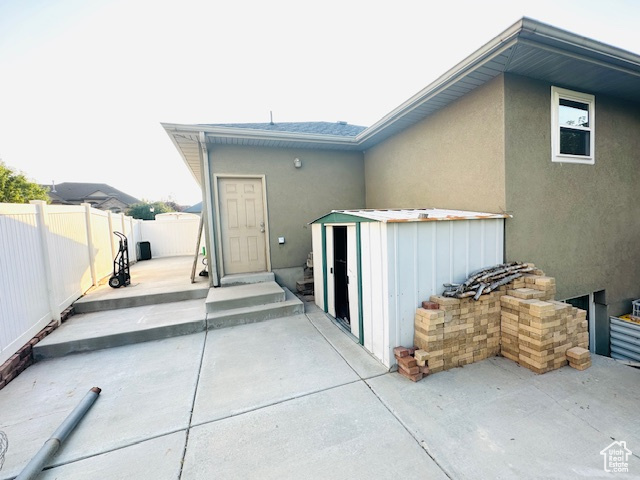 View of patio with a storage unit