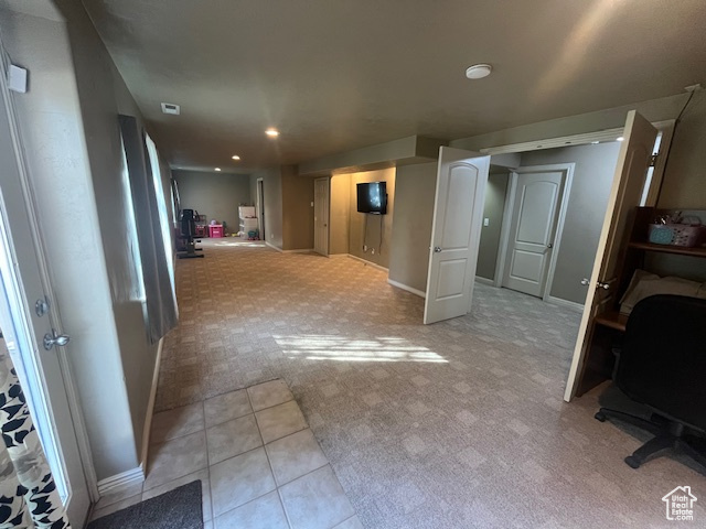 Hallway featuring light carpet