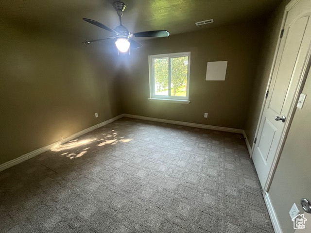 Spare room with ceiling fan and carpet