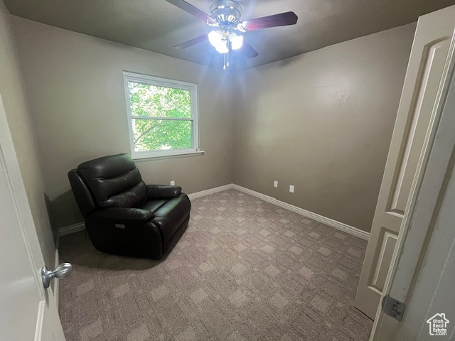 Living area with light colored carpet and ceiling fan