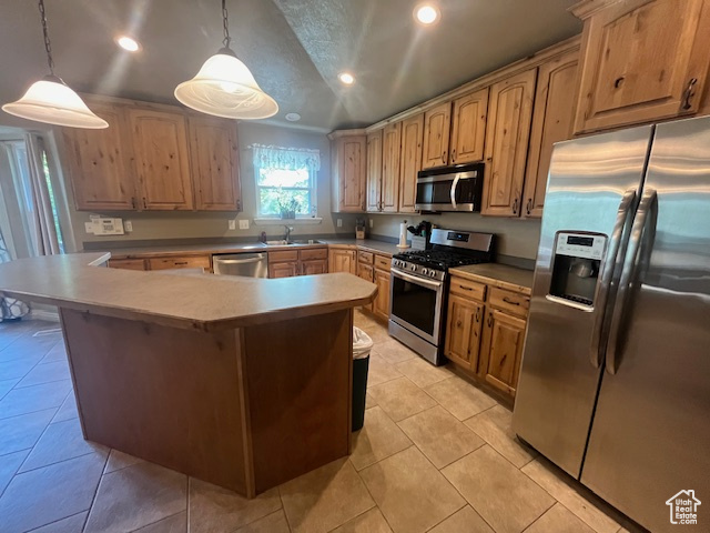 Kitchen with pendant lighting, stainless steel appliances, light tile patterned flooring, and sink