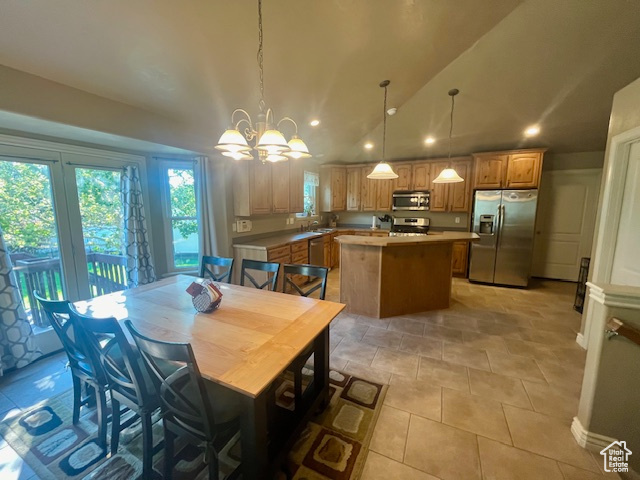 Tiled dining space with lofted ceiling, sink, and a notable chandelier