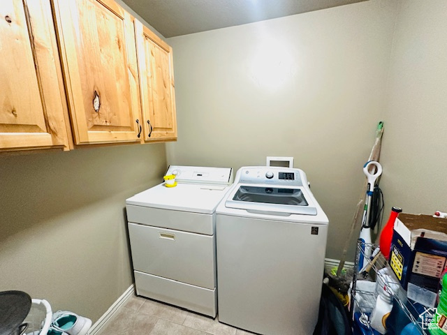 Washroom with cabinets, light tile patterned flooring, and independent washer and dryer