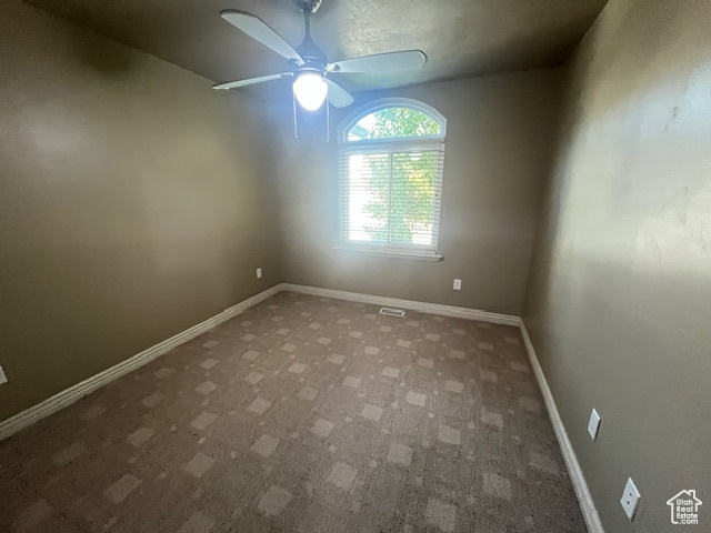 Spare room featuring ceiling fan and carpet flooring