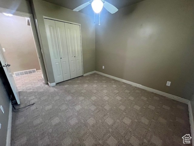 Unfurnished bedroom featuring carpet, a closet, and ceiling fan