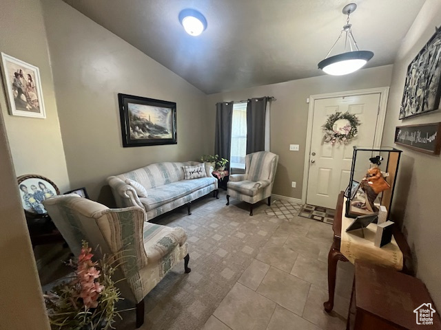 Living room featuring tile patterned flooring and vaulted ceiling