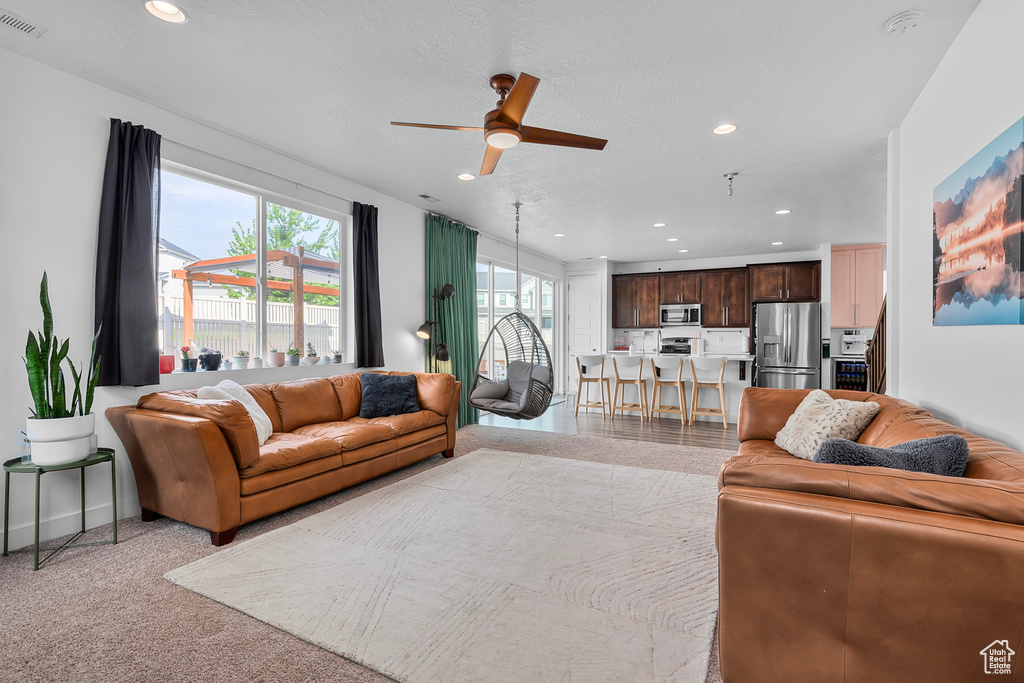 Living room with ceiling fan and light colored carpet