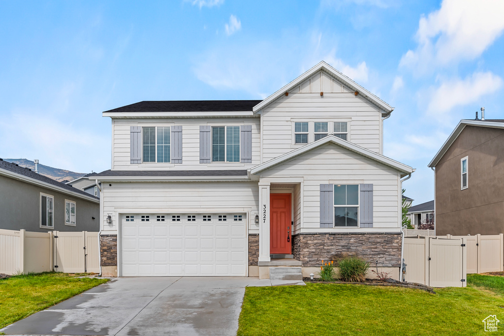 View of front facade featuring a garage and a front yard