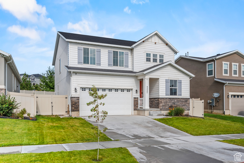 View of front of property with a front yard and a garage