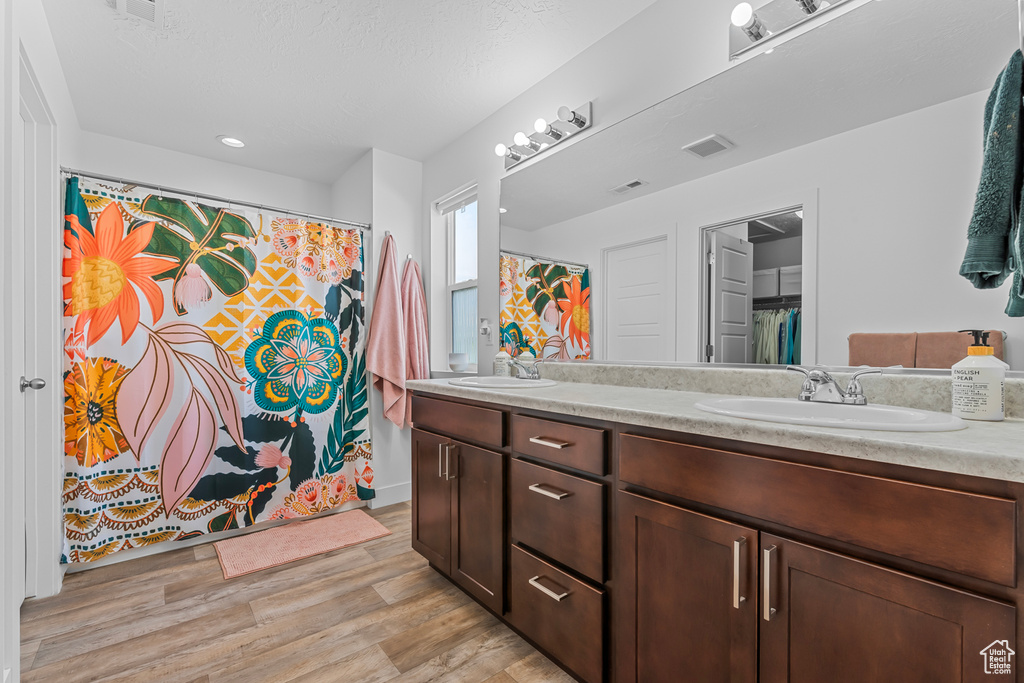 Bathroom with hardwood / wood-style floors and dual bowl vanity