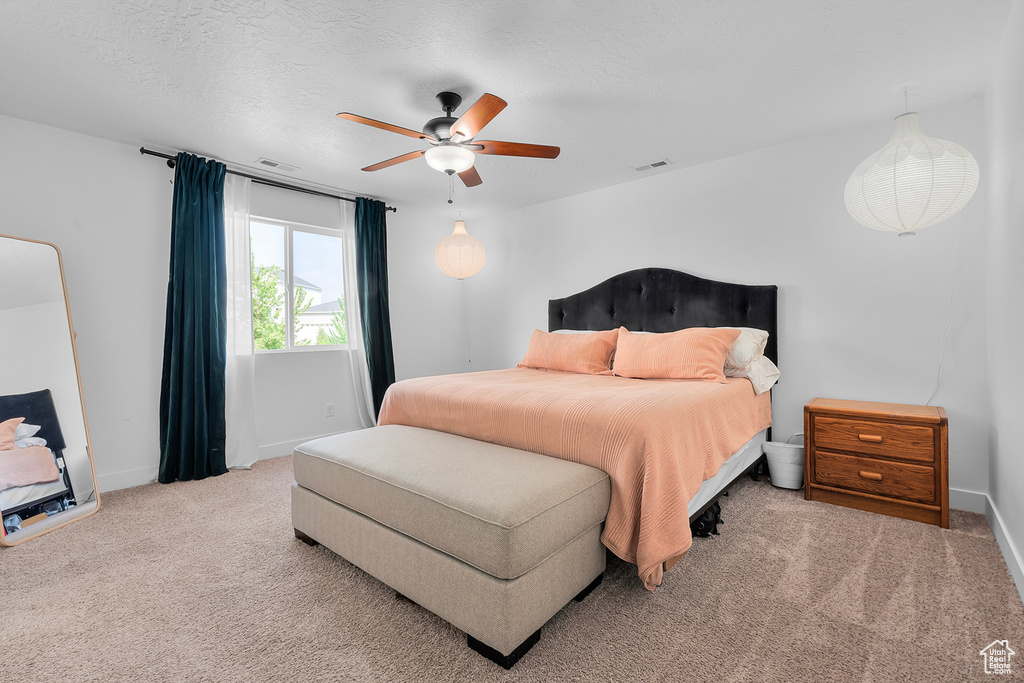 Carpeted bedroom featuring ceiling fan