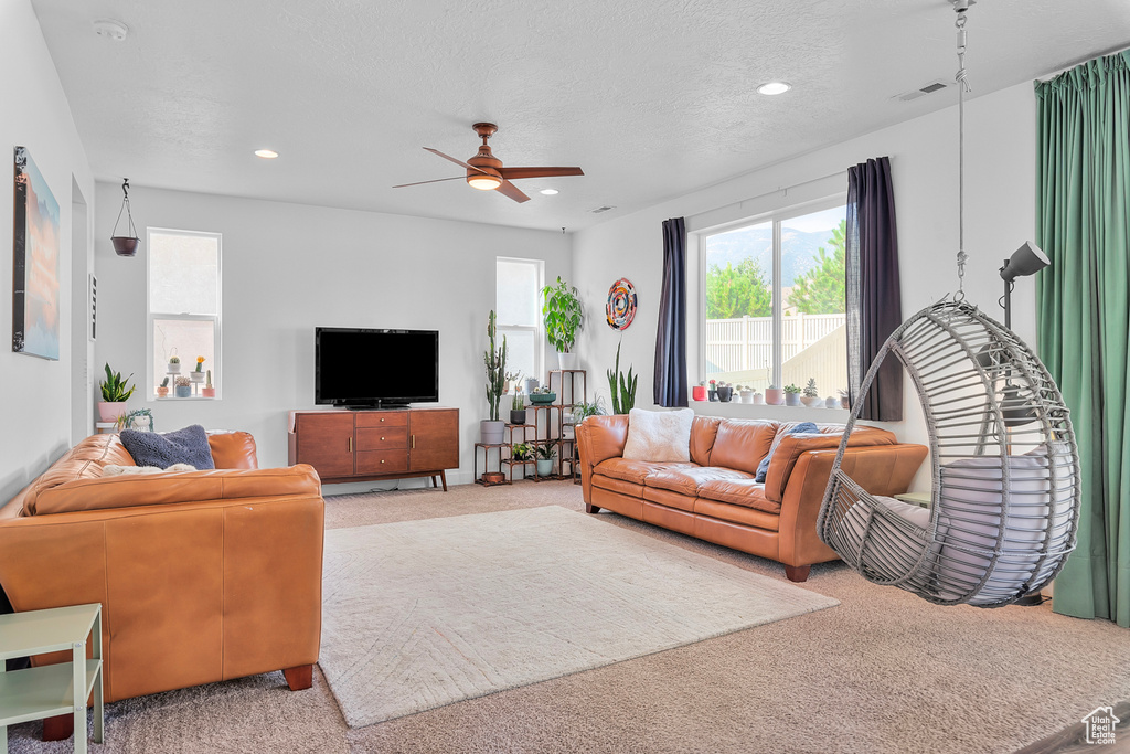 Carpeted living room with ceiling fan