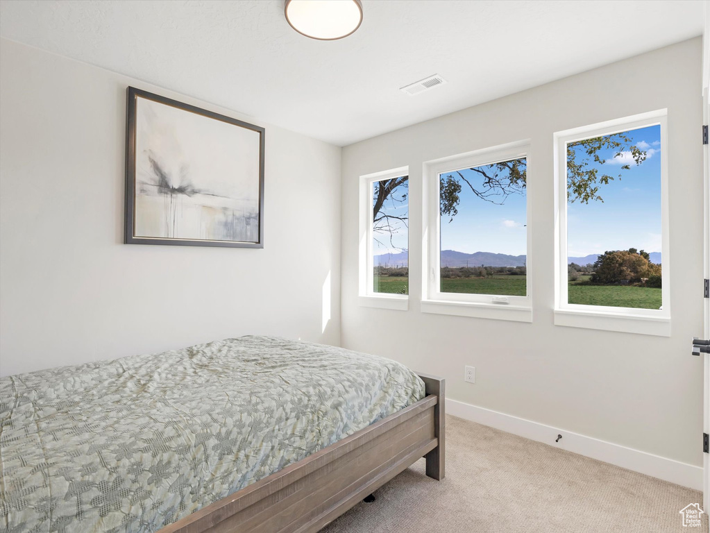 Bedroom with a mountain view and light carpet