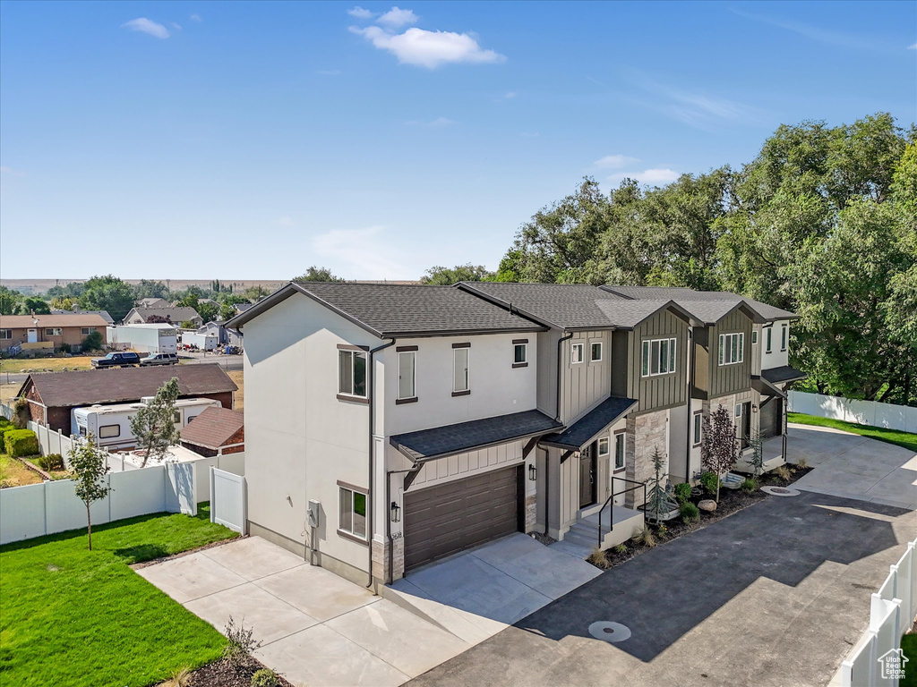 View of front of property with a garage and a front lawn