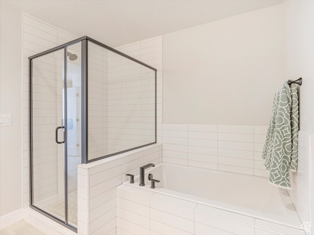 Bathroom featuring separate shower and tub and tile patterned floors