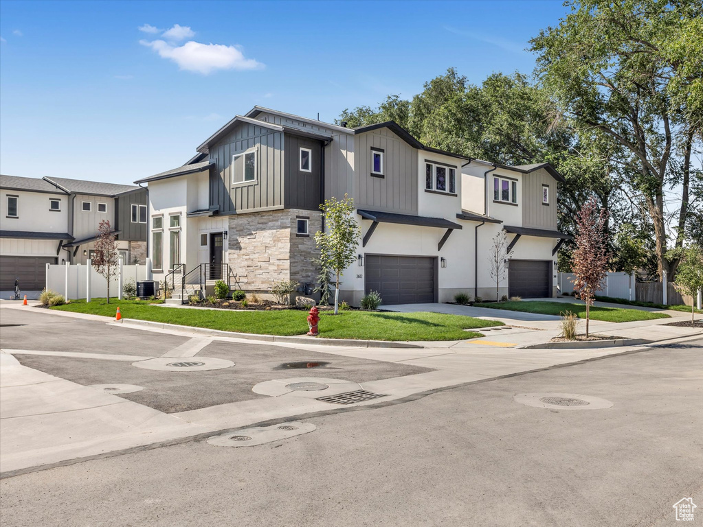 View of front of house with a garage and central AC