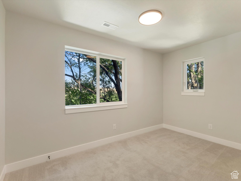 Empty room featuring light colored carpet