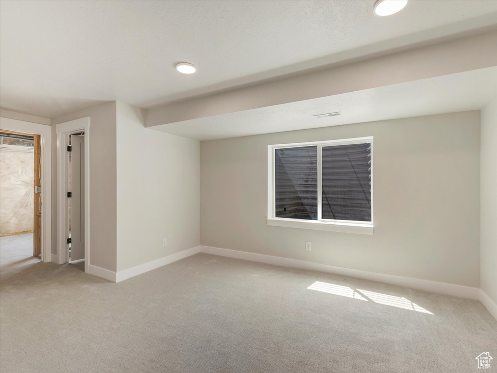 Unfurnished room featuring light carpet