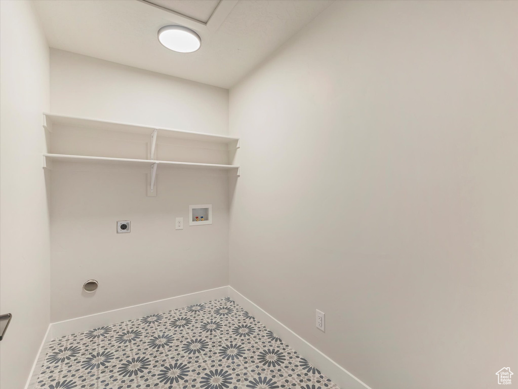 Washroom with hookup for a washing machine, tile patterned flooring, and electric dryer hookup