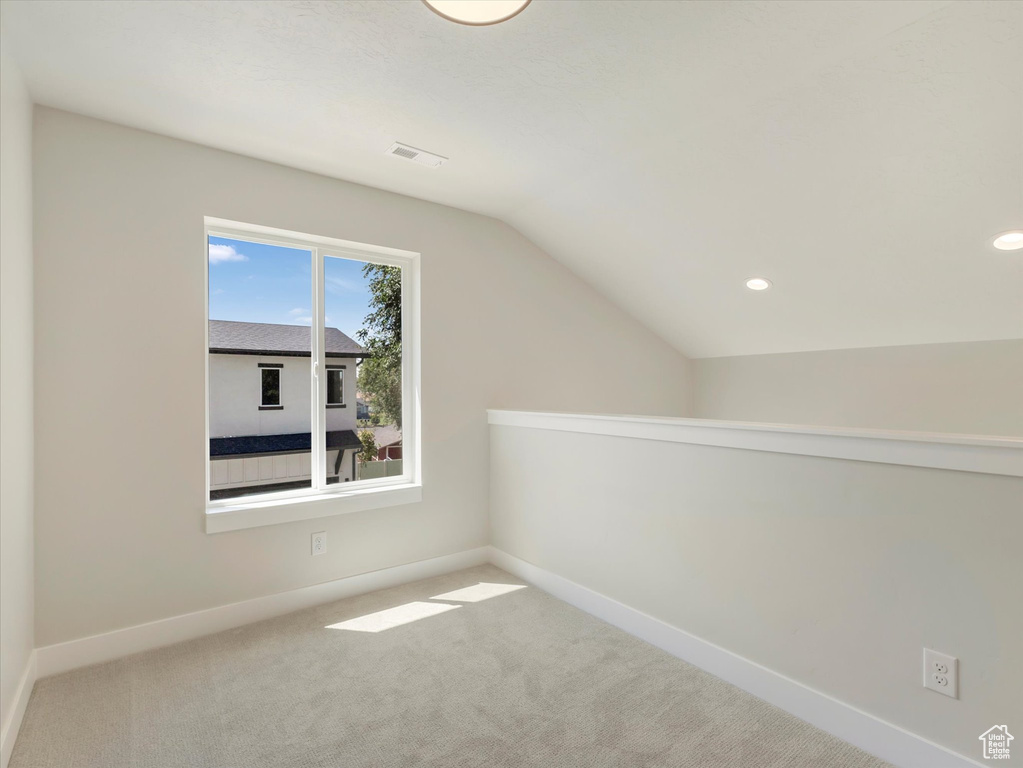 Additional living space featuring lofted ceiling and carpet floors