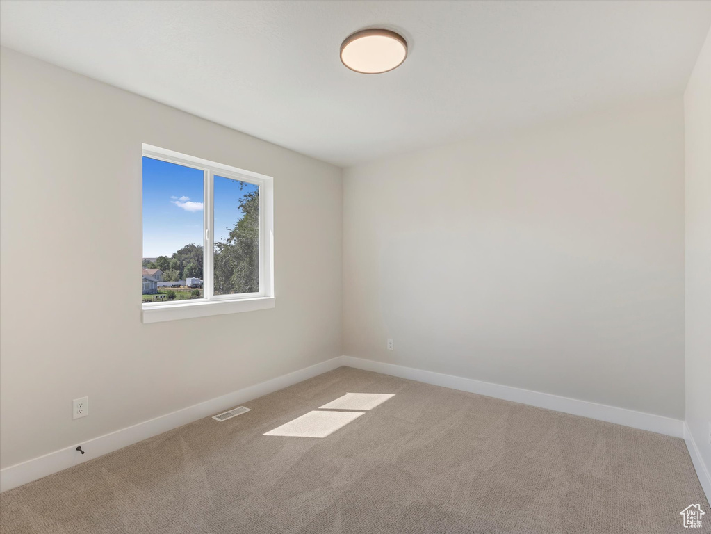 Spare room with light colored carpet