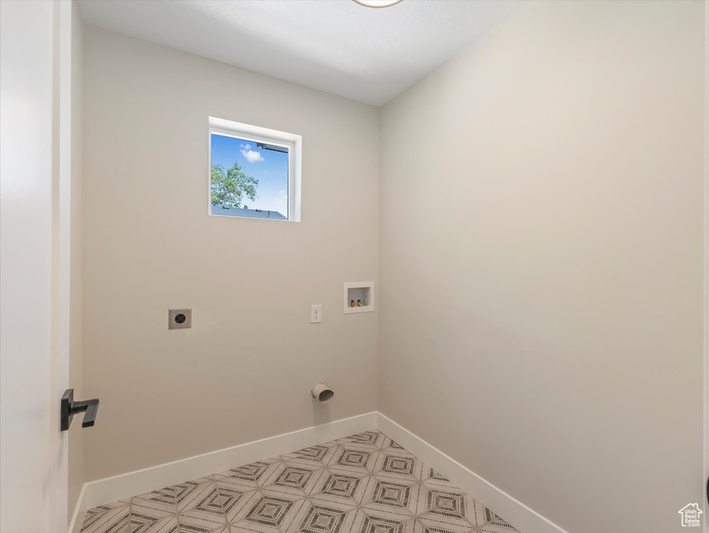 Washroom with light tile patterned flooring, hookup for an electric dryer, and washer hookup