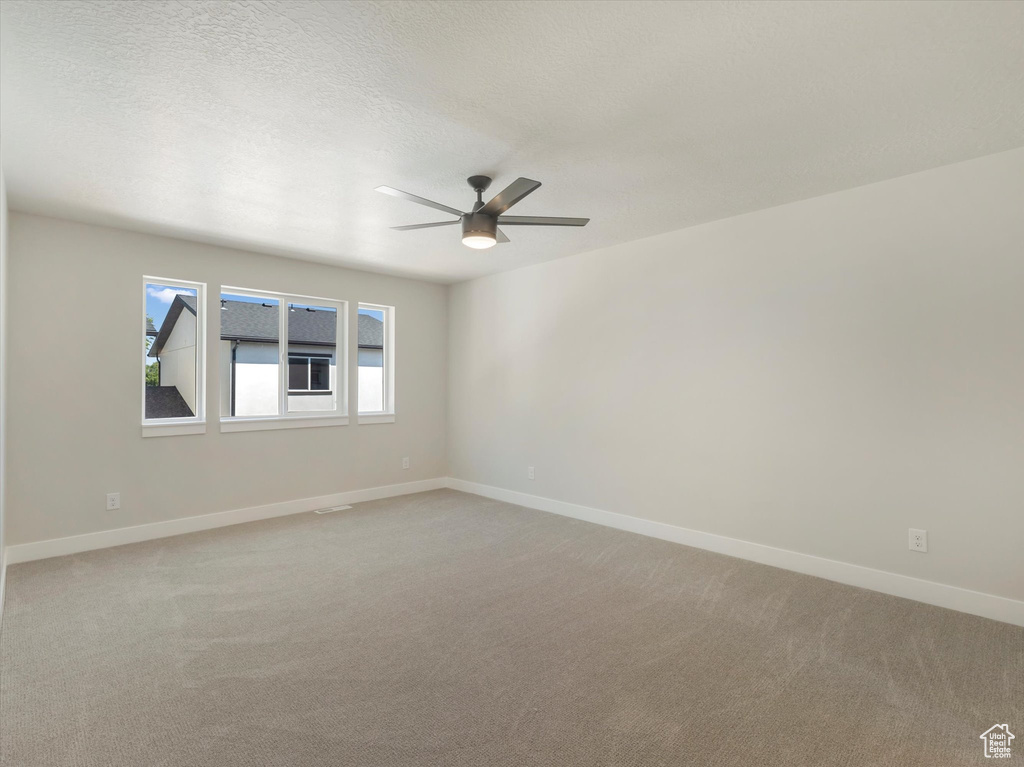 Carpeted spare room with ceiling fan