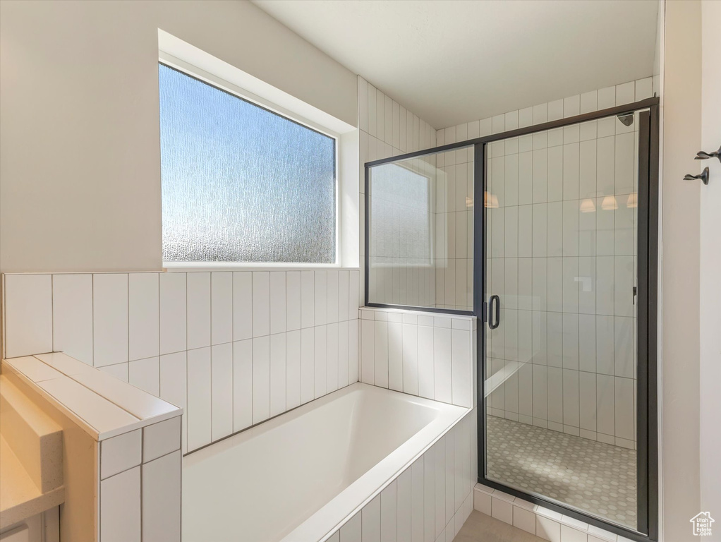 Bathroom with a healthy amount of sunlight and separate shower and tub