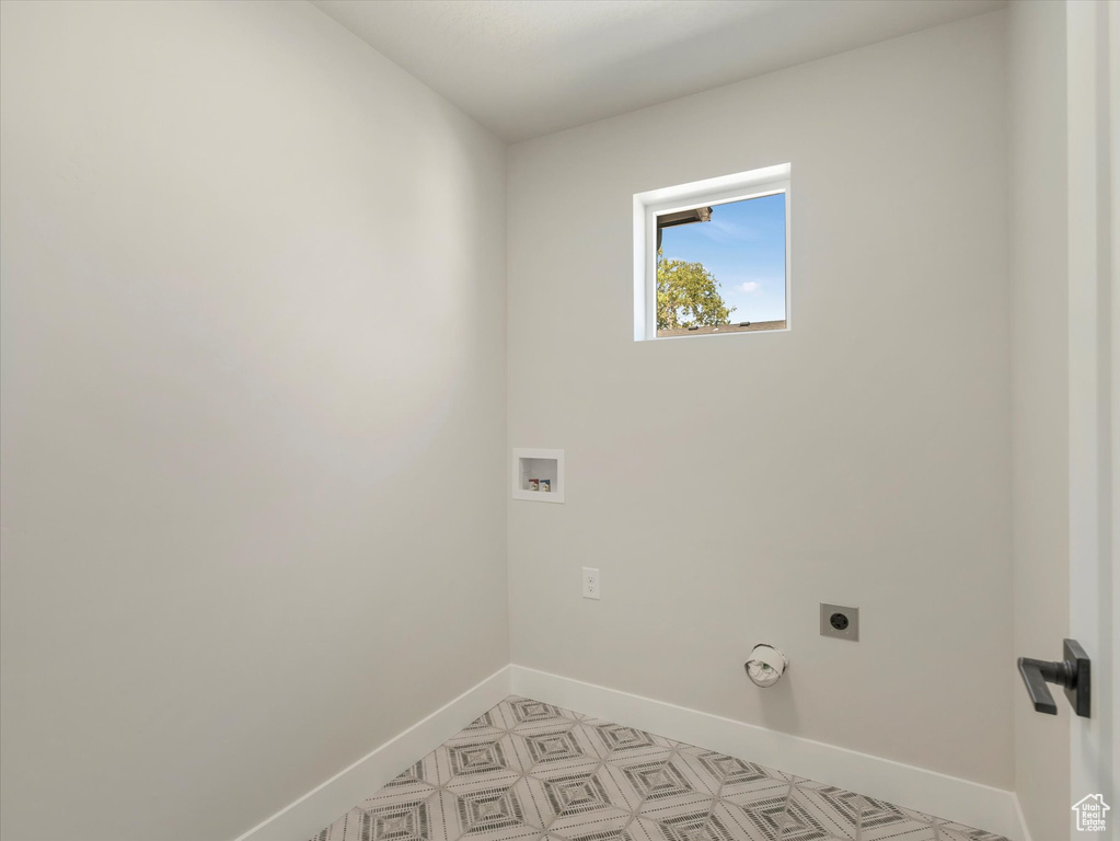 Clothes washing area with hookup for an electric dryer, washer hookup, and light tile patterned floors