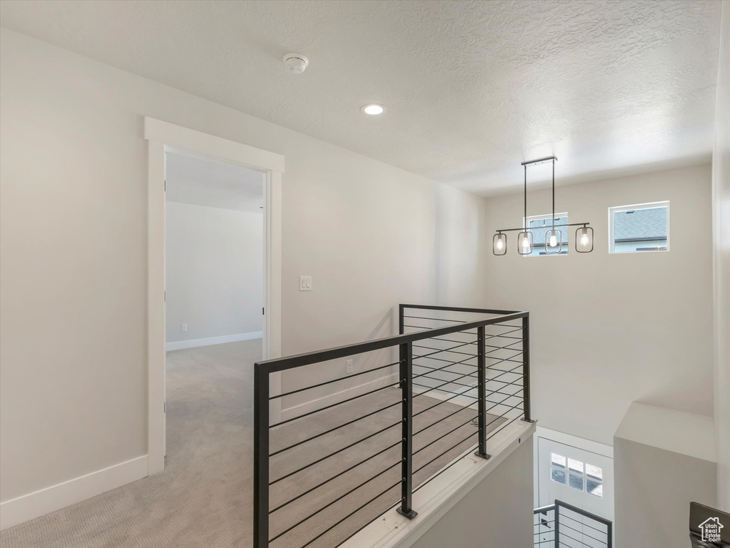 Hall with a textured ceiling and light carpet