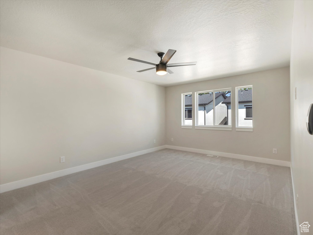 Spare room with ceiling fan and carpet flooring