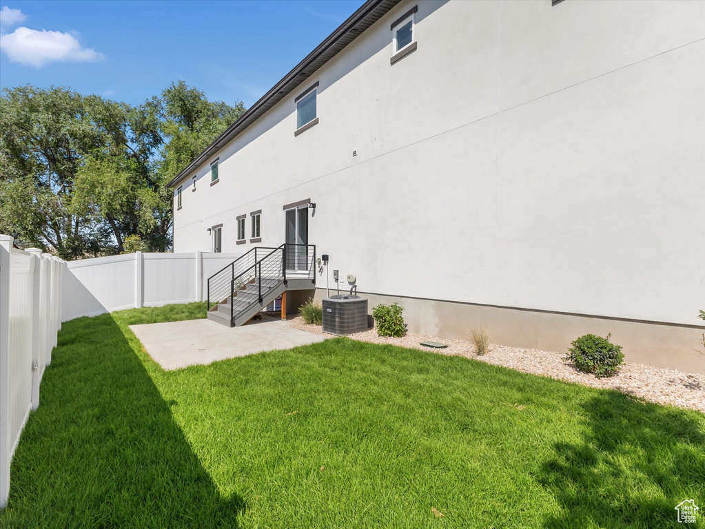 Back of house featuring cooling unit and a yard