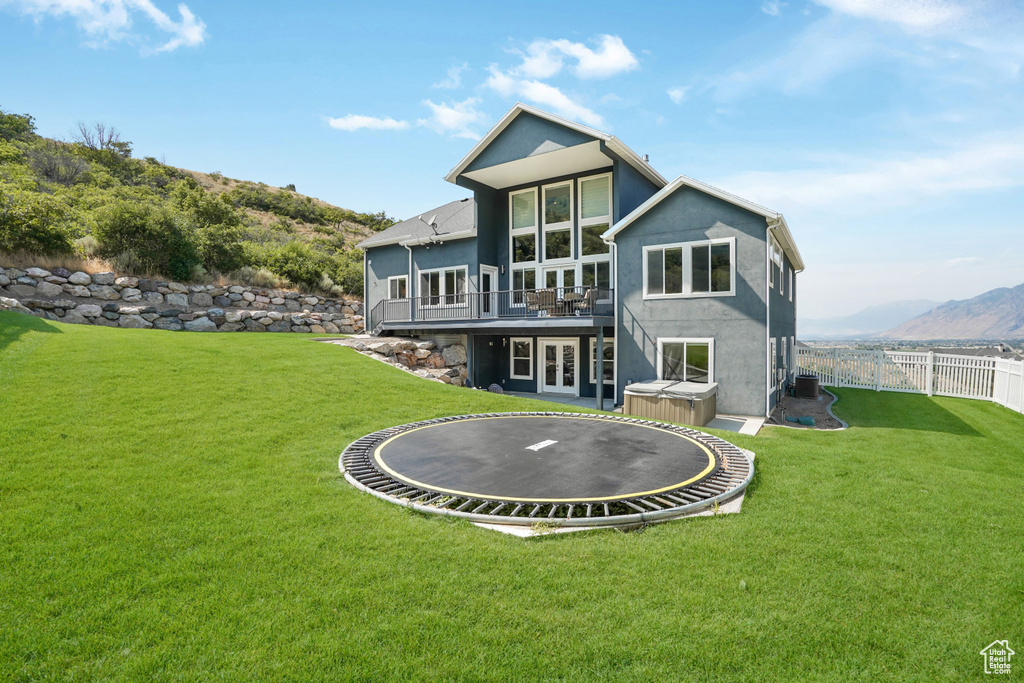 Rear view of property featuring a lawn and a mountain view