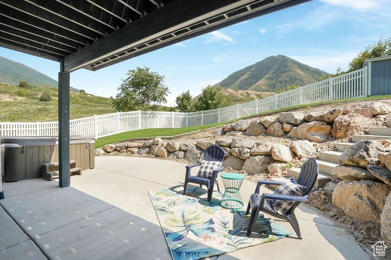 View of patio / terrace with a mountain view and a hot tub