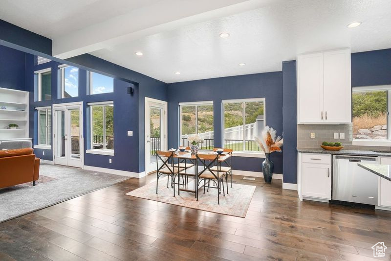 Dining space with beamed ceiling, french doors, dark hardwood / wood-style floors, and a wealth of natural light