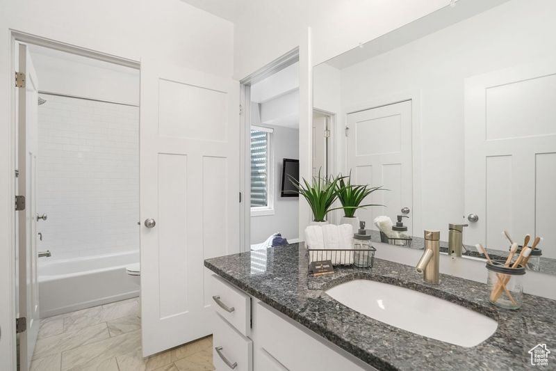 Full bathroom featuring tile patterned flooring, toilet, vanity, and bathing tub / shower combination