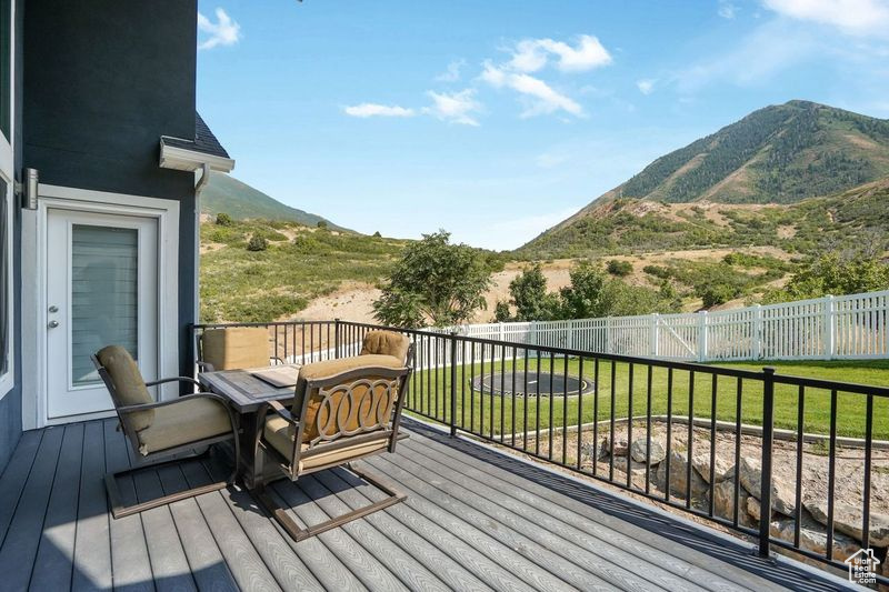 Wooden deck with a mountain view and a lawn