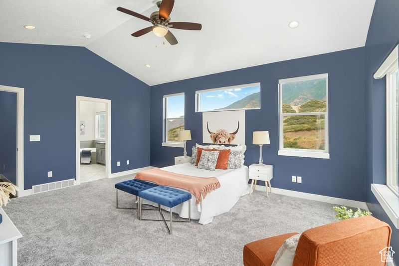 Bedroom with light carpet, lofted ceiling, ceiling fan, and ensuite bathroom