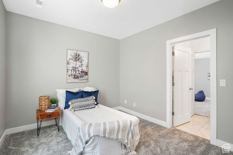 Bedroom featuring light colored carpet