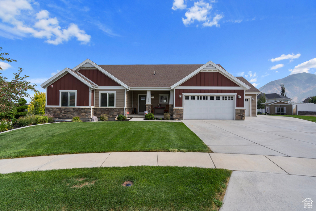 Craftsman-style house with a garage, a mountain view, and a front yard