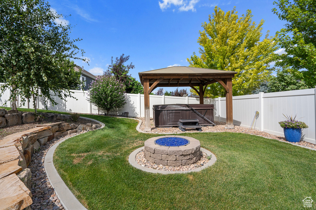 View of yard featuring a fire pit and a gazebo