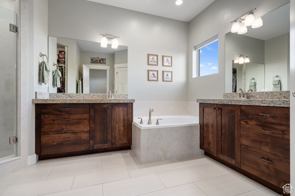 Bathroom with tile patterned floors, vanity, and separate shower and tub