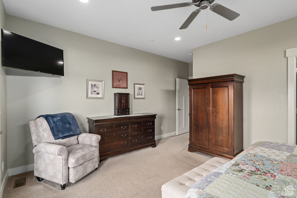 Bedroom with ceiling fan and light carpet