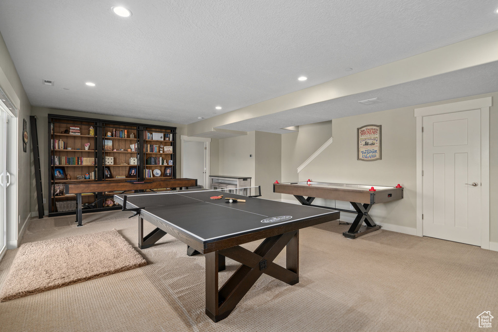 Game room with a textured ceiling and light colored carpet