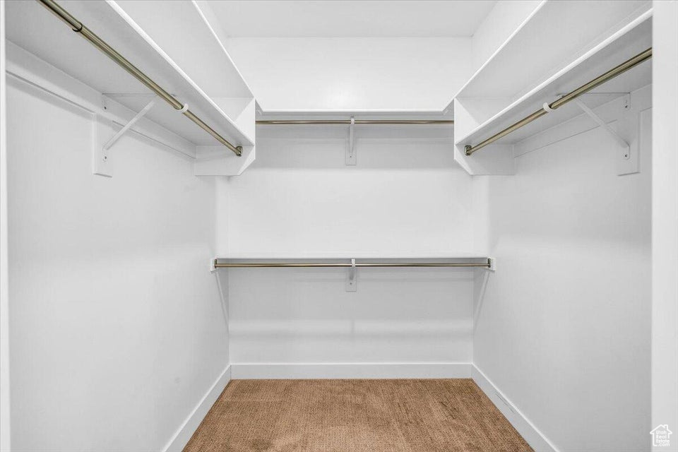 Walk in closet featuring light carpet