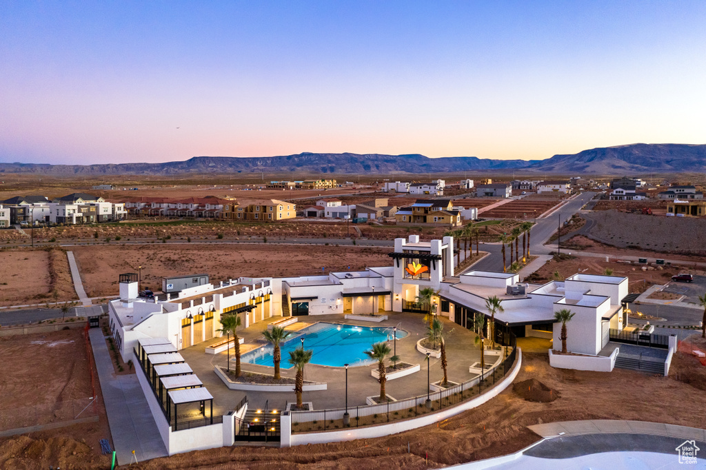 Pool at dusk with a mountain view and a patio area