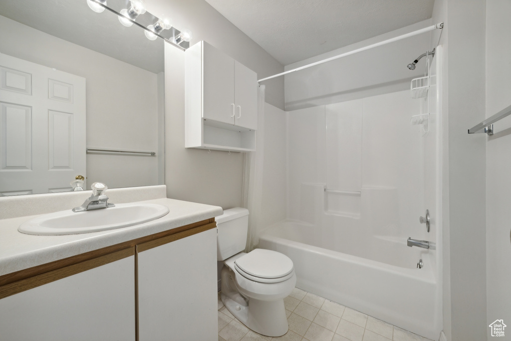 Full bathroom featuring vanity, shower / bath combination, toilet, and tile patterned flooring