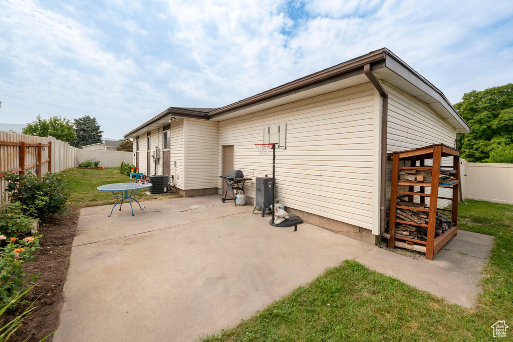 View of patio with cooling unit and a grill